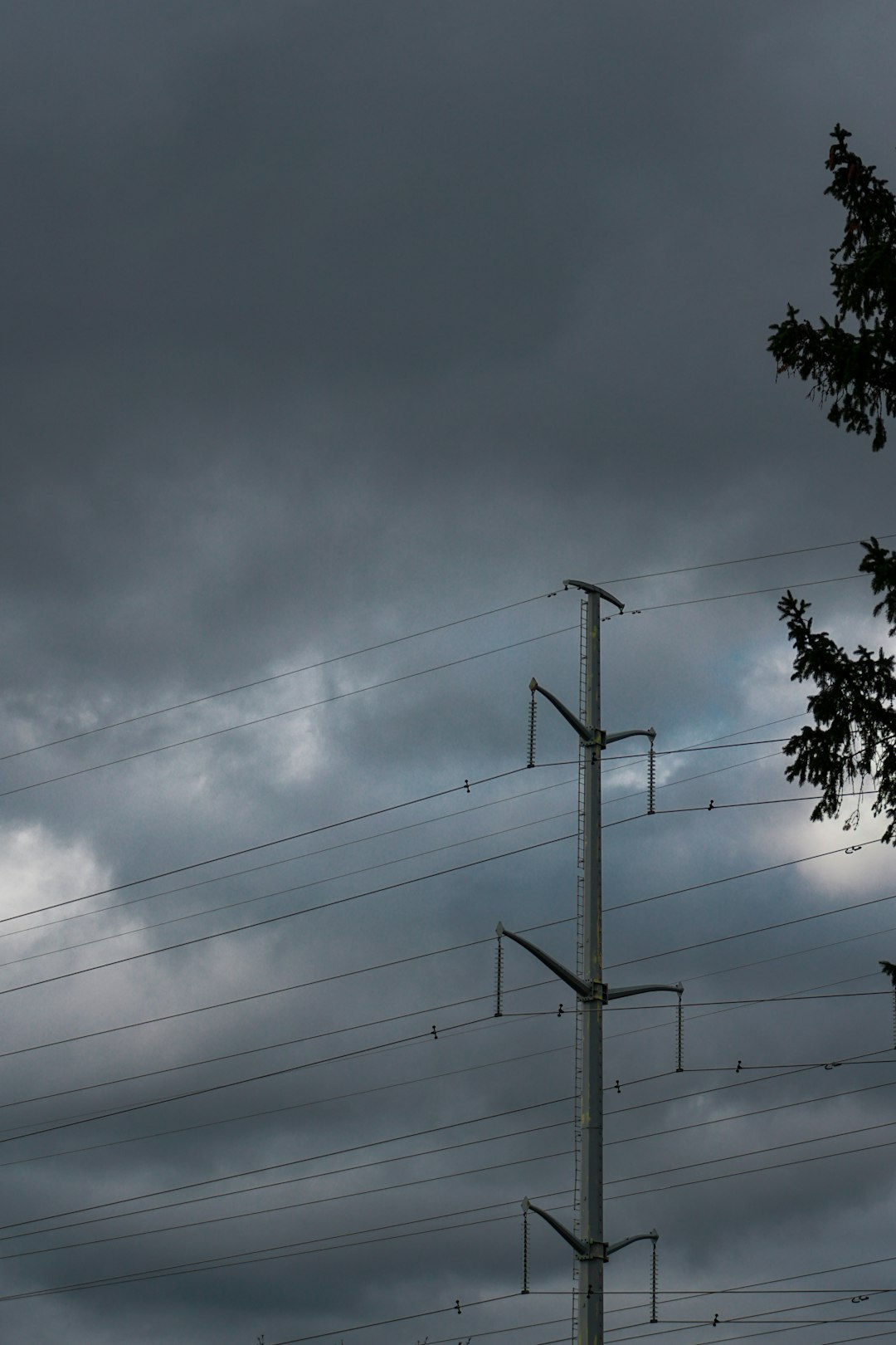 A telephone pole in front of a cloudy sky