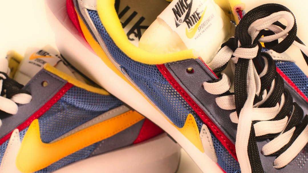 A pair of blue and yellow sneakers on a white surface